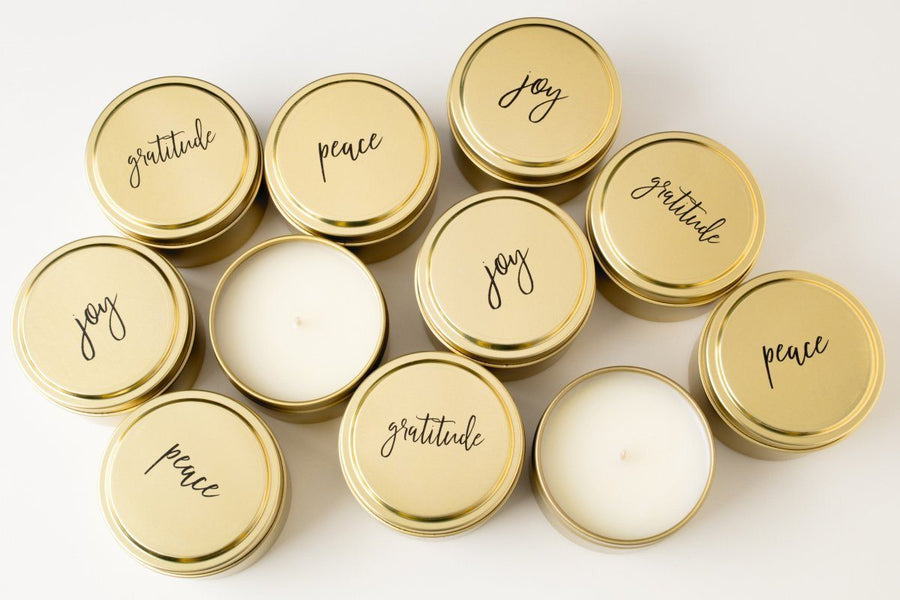 Peace, Joy and gratitude gold soy blend wholesale candles handmade by women artisans in the United States. Best holiday gift that gives back. Gold travel tin candles add beauty to the home. 